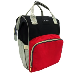 Mochila pañalera marca LAND en bloques de color negro, rojo y gris claro, con asas superiores y bolsillo frontal con cremallera dorada.