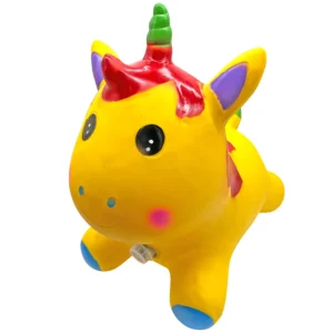 Vista en perspectiva diagonal de tres cuartos de un juguete inflable saltarín con forma de unicornio de color amarillo brillante. Se aprecian su cara sonriente, orificios nasales azules, una mejilla rosada, orejas con el interior morado, crin roja, cuerno verde y patas delanteras con base azul sobre un fondo blanco aislado. En la parte inferior del pecho destaca el dispositivo de sonido integrado. El archivo de referencia es amarillo