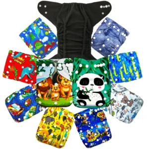 Paquete de pañales ecológicos para niño sobre fondo blanco. En la parte superior se muestra un pañal de tela lavable completamente abierto con el interior de tela gris oscuro. Debajo, diez pañales reutilizables están organizados en círculo con variados estampados infantiles: dinosaurios, leones de la selva, un oso panda comiendo bambú, textura de mezclilla, cocodrilos, perritos, motivos navideños, safari africano y carros de carreras.